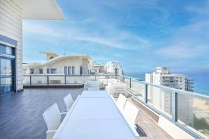 a balcony with a white table and white chairs at Luxury Penthouse in Netanya in Netanya