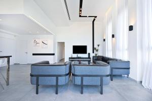 a living room with blue chairs and a couch at Luxury Penthouse in Netanya in Netanya