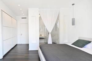 a bedroom with white walls and a large bed at Luxury Penthouse in Netanya in Netanya