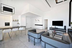 a living room with a couch and a table with chairs at Luxury Penthouse in Netanya in Netanya