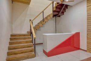 a staircase in a house with a red and white wall at Collection O Hotel Shagun Palace in Bhopal