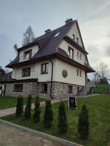 a large white house with a black roof at Willa Hajnówka in Zakopane