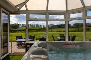 a swimming pool in a house with a view of a field at Tixall Manor Farm in Stafford