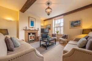 a living room with two couches and a fireplace at Alice House in Burnham Market