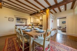 a kitchen and dining room with a wooden table and chairs at Alice House in Burnham Market