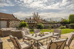 Un patio al aire libre con mesa y sillas. en Alice House, en Burnham Market
