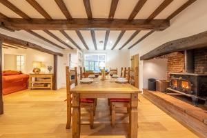 a dining room with a table and a wood stove at Owl Cottage in Great Snoring