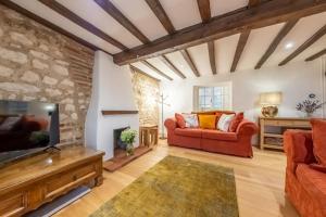 a living room with a couch and a tv at Owl Cottage in Great Snoring