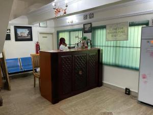 a woman sitting at a bar in a restaurant at Studio C, (Studio Apartment) Hillside Gardens in Lagos