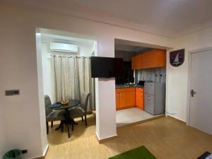 a kitchen and dining room with orange cabinets and a table at Studio C, (Studio Apartment) Hillside Gardens in Lagos
