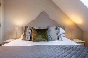 Schlafzimmer mit einem Bett mit einem großen Kopfteil in der Unterkunft 5 Manor Farm Barns in Brancaster