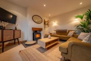 a living room with a couch and a fireplace at Maurice Cottage in Docking