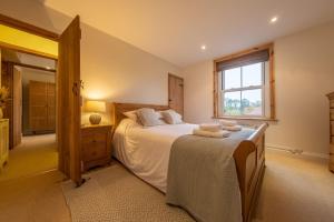 a bedroom with a large bed and a window at Maurice Cottage in Docking