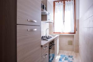 una piccola cucina con piano cottura e lavandino di Appartamento con parcheggio e Aria Condizionata a Lerici