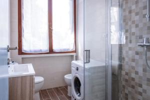 een badkamer met een toilet en een wasmachine bij Appartamento con parcheggio e Aria Condizionata in Lerici
