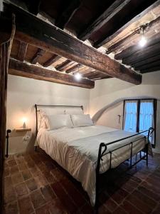 1 dormitorio con 1 cama en una habitación con techos de madera en La casa del Teatro, en Campiglia dʼOrcia