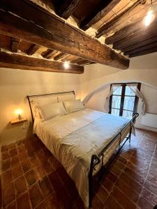 1 dormitorio con 1 cama en una habitación con vigas en La casa del Teatro, en Campiglia dʼOrcia