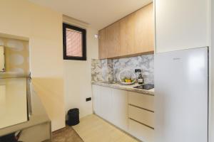 a kitchen with white cabinets and a counter top at Hotel & Apartments HEC Residence in Sveti Stefan