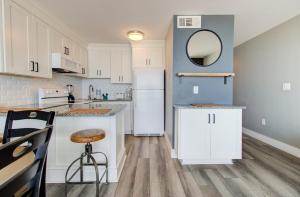 Una cocina con gabinetes blancos y un refrigerador blanco. en 0703 Atlantic Retreat by Atlantic Towers, en Carolina Beach 15 fotos más