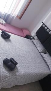 una camera da letto con un letto bianco con cuscini neri di La Casa di Argo Acquario di Genova, Parcheggio Gratuito, Stazione Sestri a Genova