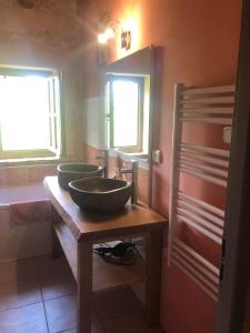 baño con 2 lavabos sobre una mesa de madera en La Riviere Esperance, en Veyrignac