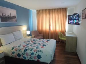 Habitación de hotel con cama y TV en Hotel Boutique Quinta Camacho en Bogotá