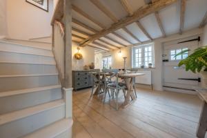 a kitchen with wooden floors and a table with chairs at The Beekeepers Cottage in Barney