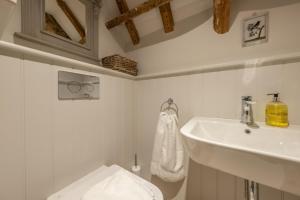 a white bathroom with a sink and a toilet at The Beekeepers Cottage in Barney