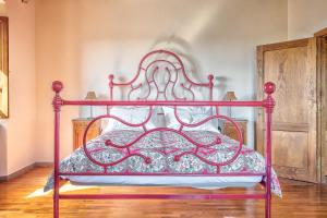 1 cama con marco rojo en una habitación en Casale - I Tre Cipressi, en Arezzo