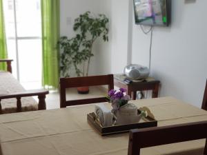 una mesa con una tetera y flores en una bandeja en Hermoso Departamento en Salta en Salta