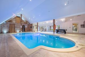 Una gran piscina en una gran sala con piscina. en Primrose Farm Barn 14, en Roughton