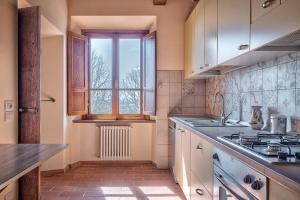 cocina con fregadero y ventana en Casale - I Tre Cipressi en Arezzo