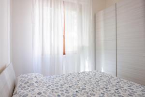 1 dormitorio con cama y ventana en Appartamento con parcheggio e Aria Condizionata, en Lerici