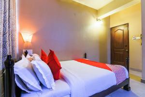 a bedroom with a bed with red and white pillows at Kams Coco De Parra in Baga