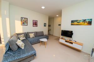 a living room with a couch and a flat screen tv at Gjiri i Lalzit - Savita Apartments - Kompleksi Turistik Lura 2 in Mullini i Danit