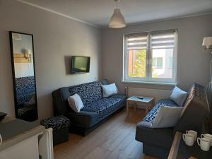uma sala de estar com um sofá e uma mesa em Pensjonat Basia em Mielno