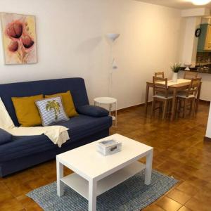 a living room with a blue couch and a table at Apartamento La Playa , Los Cancajos La Palma in Los Cancajos