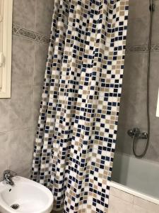 a bathroom with a shower curtain and a sink at Ayuntamiento Alicante in Alicante