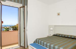 a bedroom with a bed and a sliding glass door at Hotel Lucerna in Castiglione della Pescaia