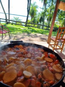 a pan of food with meat and vegetables at Cabaña panorámica sobre el PARANÁ y Pesca in Itá Ibaté