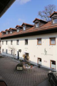 a large white building with a courtyard in front of it at Hotel Bockmaier in Oberpframmern