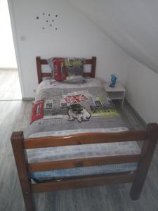 ein Bett mit einem Holzrahmen in einem Schlafzimmer in der Unterkunft LE CHANT DES OISEAUX arrivée autonome in Sorbais