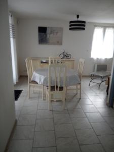 ein Esszimmer mit einem Tisch und Stühlen in der Unterkunft LE CHANT DES OISEAUX arrivée autonome in Sorbais