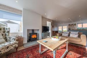 a living room with a table and a fireplace at Marsh Tide 4 in Brancaster