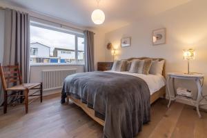 a bedroom with a bed and a large window at Marsh Tide 4 in Brancaster