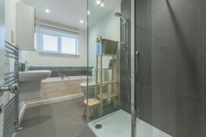 a bathroom with a shower and a sink and a toilet at Marsh Tide 4 in Brancaster +19 photos
