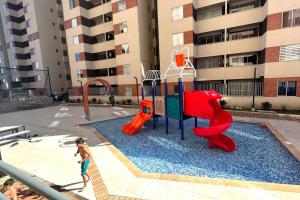 a young child playing on a playground in a courtyard at Espectacular Apartamento en Marinilla, Wifi 200MB in Marinilla