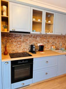 uma cozinha com armários brancos e um forno com placa de fogão em Brand new, feel at home residence em Timisoara