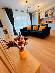 uma sala de estar com um sofá e uma mesa com flores em Brand new, feel at home residence em Timisoara