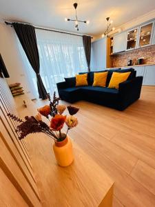 a living room with a couch and a table with flowers at Brand new, feel at home residence in Timişoara